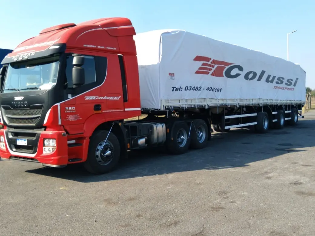 Tractora Iveco 360 de Transporte Colussi con semirremolque de lona y barandas