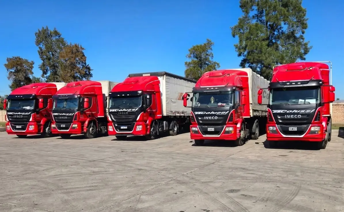 Cinco tractoras Iveco de la flota propia de Transporte Colussi alineadas en la playa de maniobras